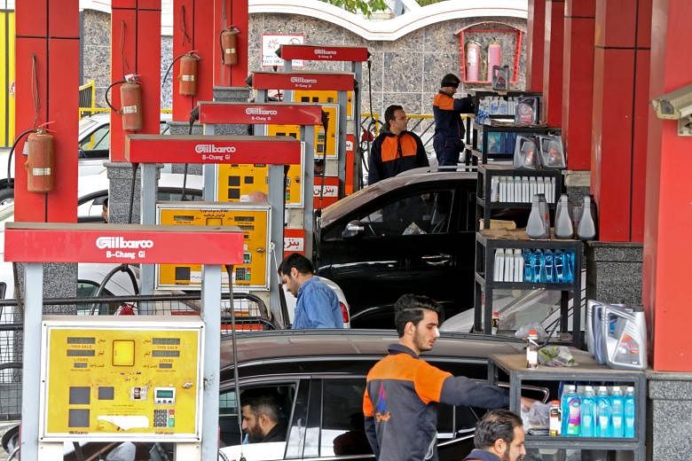 Iranian motorists filling their vehicles' tanks at a petrol station in the capital Teheran yesterday.