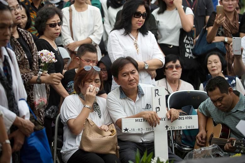 Mr and Mrs Johan Haris Saroinsong (seated), the parents of 23-year-old undergraduate Hizkia Jorry Saroinsong, a victim of the ill-fated Lion Air flight, at the funeral of their son in Jakarta yesterday.