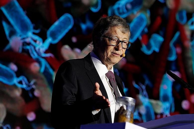 Microsoft co-founder Bill Gates pointing to a jar of human faeces during his speech to illustrate the importance of improving sanitation.