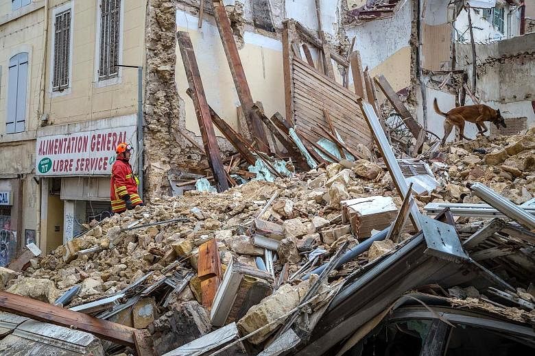 A fireman and a dog searching at the site where two buildings collapsed in Marseille, France, on Monday.