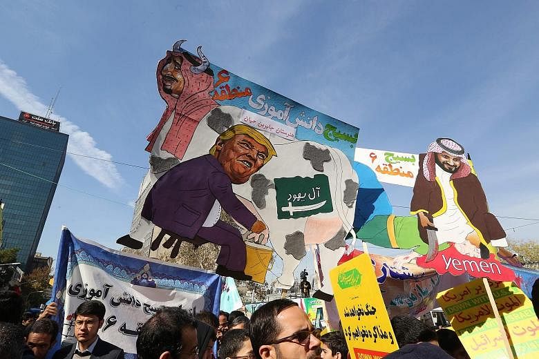 Iranians carrying placards that mock President Donald Trump, Saudi Arabia's King Salman and Crown Prince Mohammed bin Salman during a protest outside the former US embassy in Teheran on Sunday.