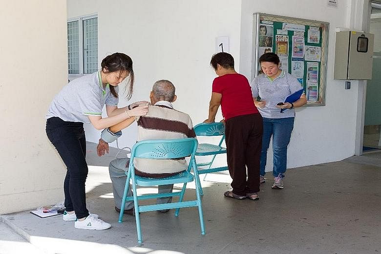 Staff from the Geriatric Education and Research Institute conduct blood pressure checks prior to carrying out a simple exercise session for older adults.