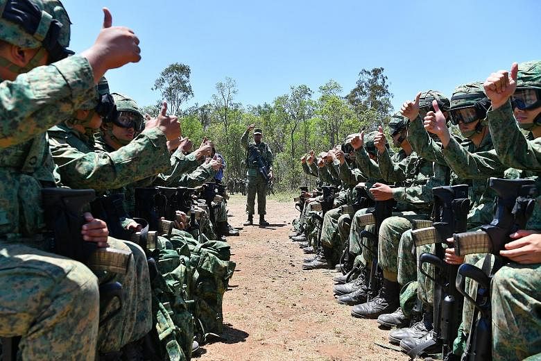 Soldiers from 1st Guards Battalion give a thumbs-up sign after they board a mock-up of a helicopter as part of their rehearsals on the procedures to follow when boarding and disembarking. Captain (Dr) Jeriel Tan (at left) and medics attend to a "casu