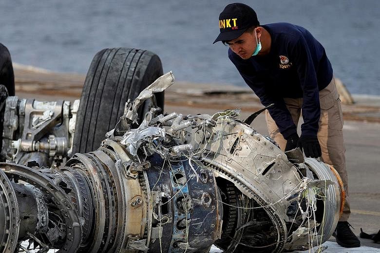 An Indonesian official examining a turbine engine from the crashed Lion Air jet at Tanjung Priok port in Jakarta on Sunday. The plane crashed on Oct 29 en route to Pangkal Pinang from Jakarta, killing all 189 people on board.