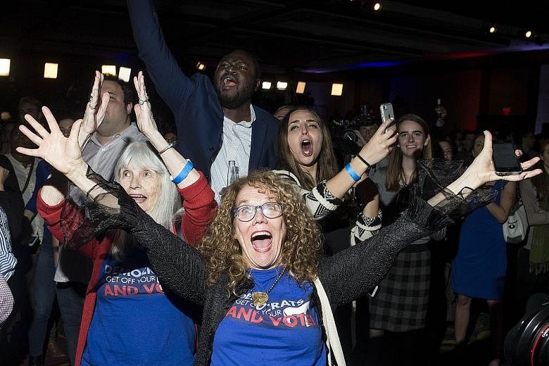Democratic Party supporters cheering at an election watch party in Washington after news that the Democrats had gained control of the House of Representatives. Their majority enables them to block legislation and launch investigations into President 