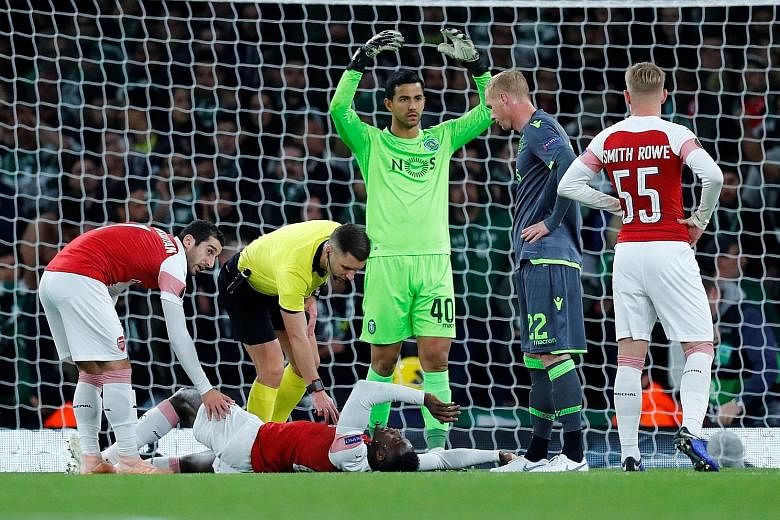 Referee Gediminas Mazeika and Arsenal's Henrikh Mkhitaryan check on Danny Welbeck after the striker suffered a potentially season-ending ankle injury in the Europa League Group E encounter at the Emirates Stadium on Thursday.
