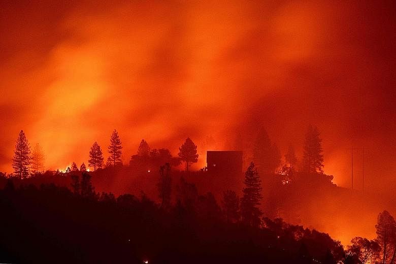 Flames from the so-called Camp Fire burning near a home atop a ridge near Big Bend, California, last Saturday. The fire has killed at least 23 people.