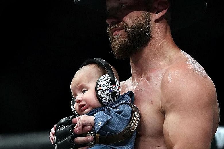 Donald Cerrone, with five-month-old son Dacson Danger, celebrating his win over Mike Perry in their welterweight bout, his first fight as a father.