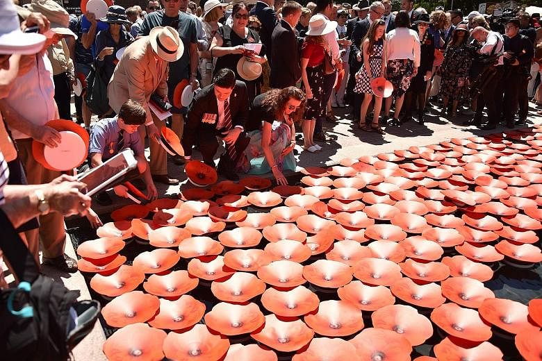 War veterans and members of the public floating giant poppies at the Anzac war memorial in Sydney yesterday. Almost 62,000 of the over 400,000 Australian federation's citizens who enlisted died in the trenches.