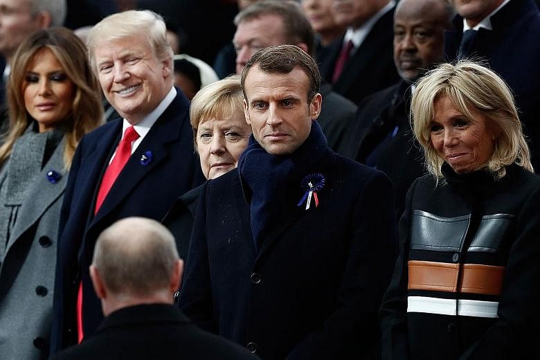 From left: US First Lady Melania Trump, US President Donald Trump, German Chancellor Angela Merkel, French President Emmanuel Macron and his wife Brigitte welcoming Russian President Vladimir Putin.