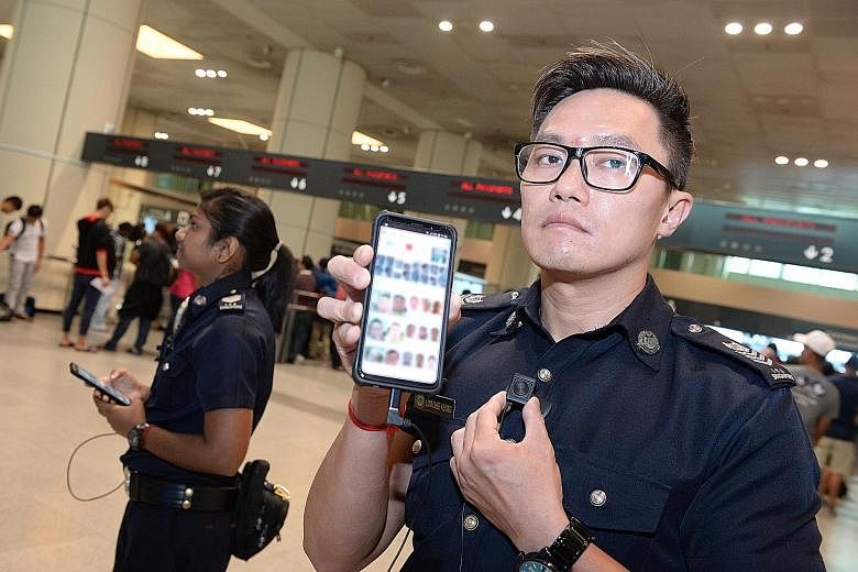 Above: An ICA patrol officer with his mobile device which would alert him when his mobile camera, worn on his shirt, detects a person of interest. Left: ICA officers demonstrating the use of the BioScreen Multi-Modal Biometric Screening System, which
