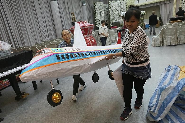 A paper plane is among the offerings to be burnt at Mr Louis Cha's funeral in Hong Kong today.