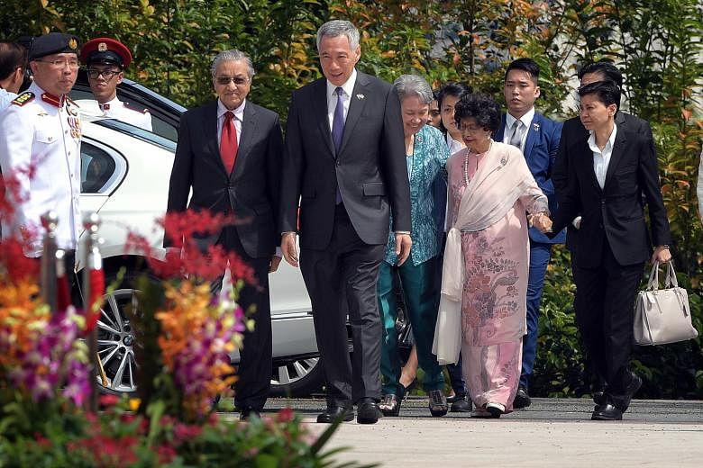 Malaysian Prime Minister Mahathir Mohamad and his wife Siti Hasmah Mohamad Ali being accompanied by Prime Minister Lee Hsien Loong and Mrs Lee on their arrival at the Istana yesterday.