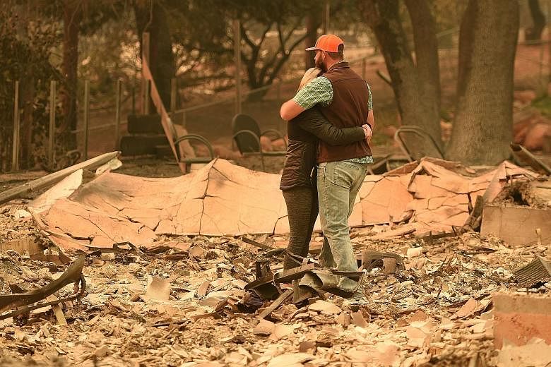 Mr and Mrs Chris Brown of the town of Paradise looking at the burnt remains of their house after wind-whipped flames tore through the region, leaving death and devastation in their wake.