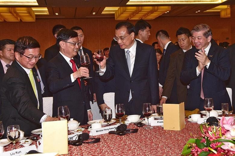 Visiting Chinese Premier Li Keqiang exchanging a toast with Finance Minister Heng Swee Keat at a welcome dinner yesterday hosted by the Singapore Chinese Chamber of Commerce and Industry (SCCCI) and Singapore Business Federation (SBF). With them are 