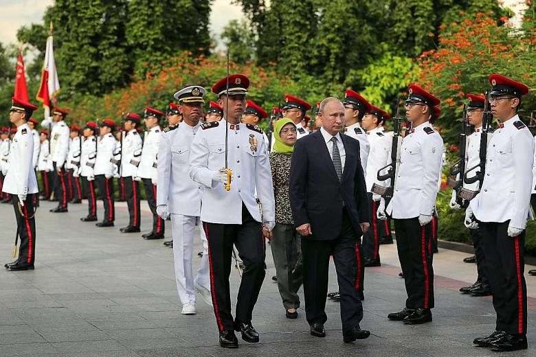 Russian President Vladimir Putin reviewing the guard of honour with Singapore President Halimah Yacob at the Istana yesterday. Singapore President Halimah Yacob and Russian President Vladimir Putin unveiling the cornerstone yesterday at the groundbre