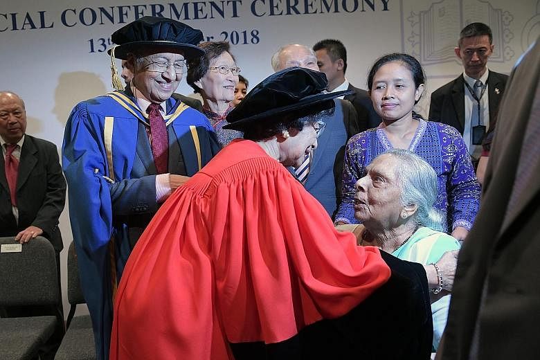 Tun Dr Mahathir and his wife, Tun Dr Siti Hasmah Mohamad Ali, speaking with an old friend, Dr Sundrai Lily Sarma, after the ceremony. Singapore President and NUS Chancellor Halimah Yacob conferring the honorary doctorate in law on Malaysian Prime Min