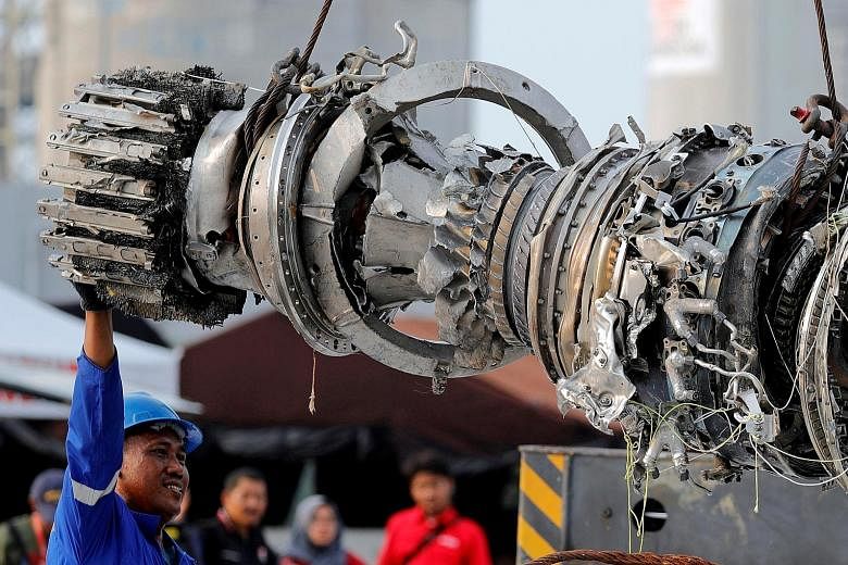 A turbine engine of the Lion Air flight 610 jet being lifted at a port in Jakarta. Boeing said it is helping in probes into the crash but did not directly address why it did not do more to stress the changes in the anti-stall system.