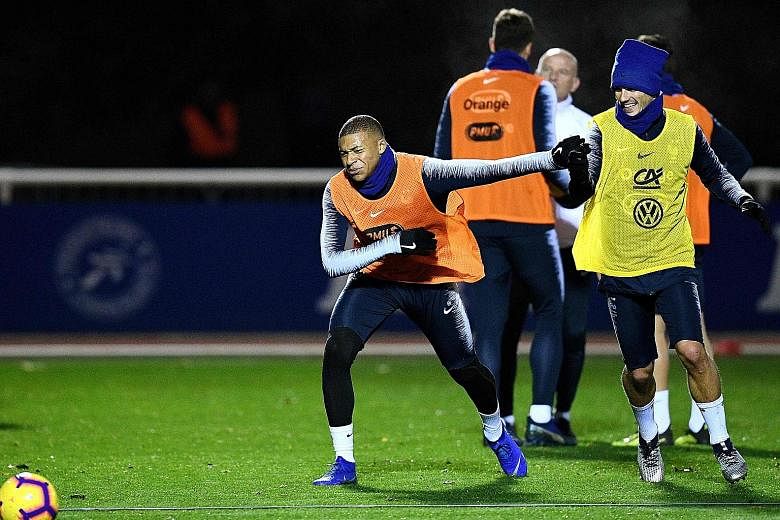 France's attacking duo Kylian Mbappe (far left) and Antoine Griezmann having a playful tussle during training on Tuesday. The French need only a draw against the Netherlands to secure their berth in the Uefa Nations League Finals.