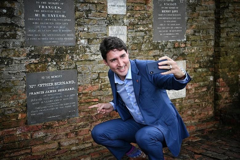Canadian Prime Minister Justin Trudeau sending a video text of his maternal great-great-great-great-grandmother Esther Farquhar Bernard's memorial plaque to his son at Fort Canning Park yesterday.