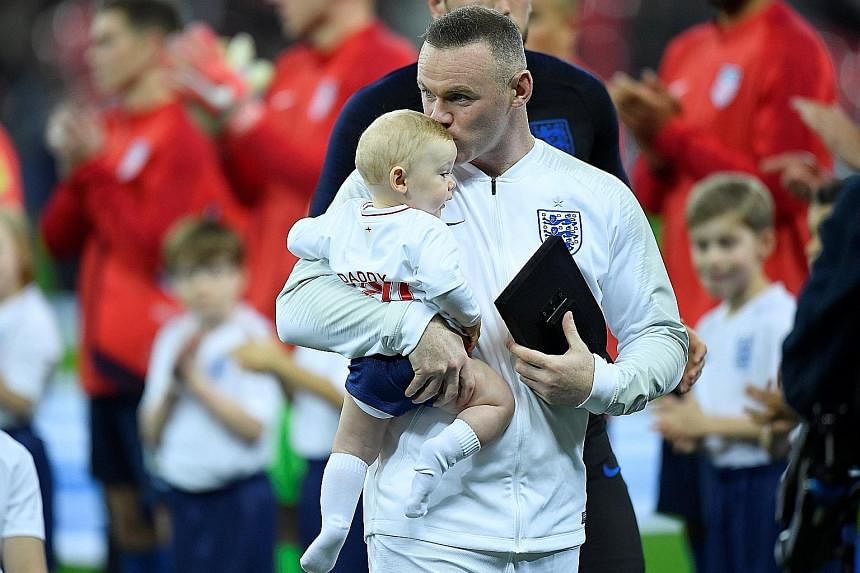 Wayne Rooney with his son, Cass Mac Rooney, after receiving an award for being England's top goalscorer with 53 goals before the match. He entered the game for his 120th and final appearance for England just before the hour mark