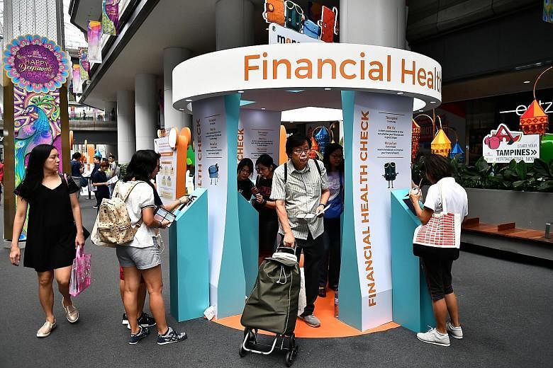 Visitors at the MoneySense roadshow at Our Tampines Hub yesterday. The new initiatives announced at the roadshow are part of government efforts to boost financial literacy among Singaporeans. Government agencies will also enhance their services to he