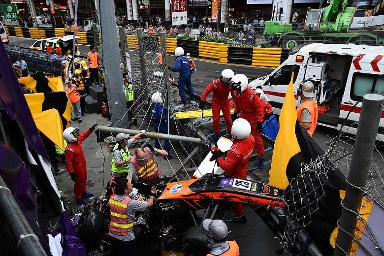 Race personnel and pit crew extricating German driver Sophia Florsch after she flew over the barriers and crashed into a photographers' bunker at high speed during the Formula Three race at yesterday's Macau Grand Prix. The 17-year-old will undergo s