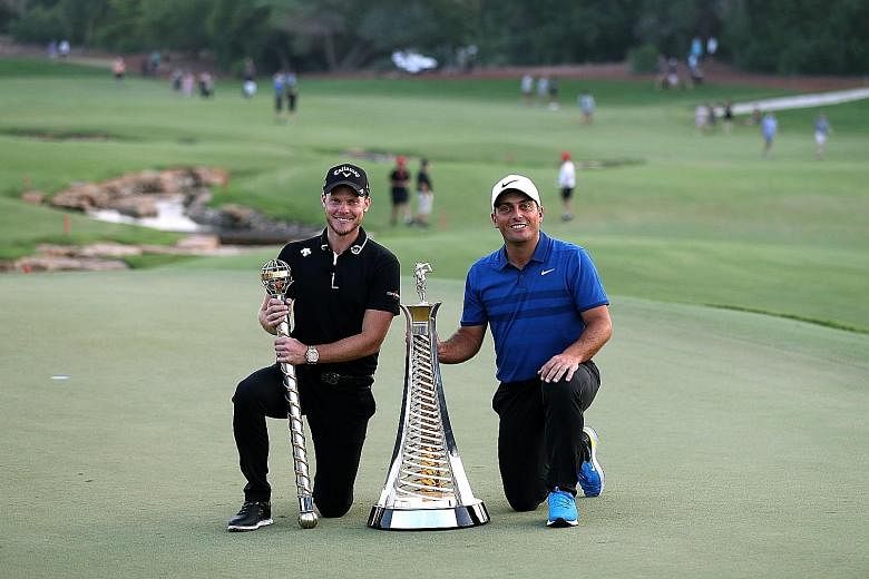 Danny Willett of England (left) posing with the DP World Tour trophy next to Francesco Molinari of Italy and his European Tour Race to Dubai trophy at the Jumeirah Golf Estates in Dubai yesterday.