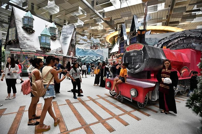 Visitors soaking in the atmosphere at Hogsmeade Village, which has been recreated at Changi Airport's Terminal 3 Departure Hall. "A Wizarding World Holiday at Changi" was launched last Friday, and features four life-size set-ups, inspired by prominen