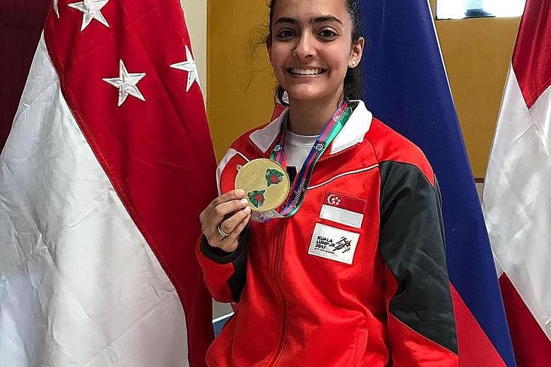 Left: Amita Berthier, wearing her 2017 SEA Games tracksuit, with her gold from the Junior World Cup leg in Guatemala. Below: Amita in her 15-8 loss to China's Huo Xingxin in the individual foil round of 16 at the Asian Games in August. She was in the