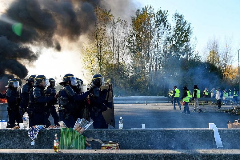 Riot police facing off against protesters opposing rising fuel prices in Bordeaux yesterday. Demonstrators blocked access to fuel depots and stopped traffic on major roads in France, after the government refused to back down on fuel tax hikes despite