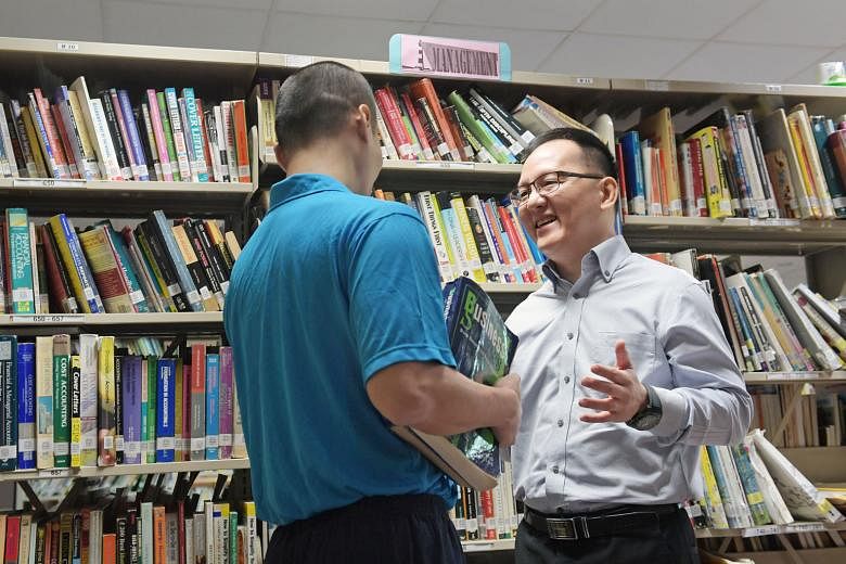 Ngee Ann Polytechnic lecturer Wong Yew Fei with an inmate at the Prison School yesterday. For the first time, inmates can enrol in a course leading to the Diploma in Business Practice (International Supply Chain Management). The qualification can ass