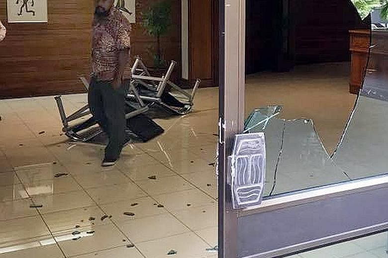 Papua New Guinea police and soldiers (above) outside the Parliament building in the capital Port Moresby yesterday. They stormed Parliament and smashed windows and furniture (below) to demand payment of the special Apec duty allowance.