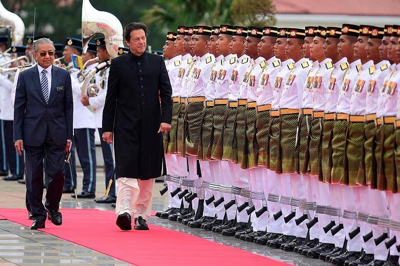 Malaysian Prime Minister Mahathir Mohamad (left) and Pakistani Prime Minister Imran Khan inspecting a guard of honour at the Prime Minister's Office in Putrajaya, Malaysia, yesterday. Mr Khan, whose two-day visit ended yesterday, was on his first vis