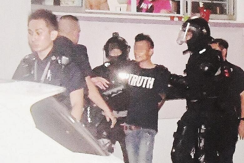 One of the two suspects being led away after a four-hour stand-off with the police when the duo refused to open the door of their flat in Jurong West.