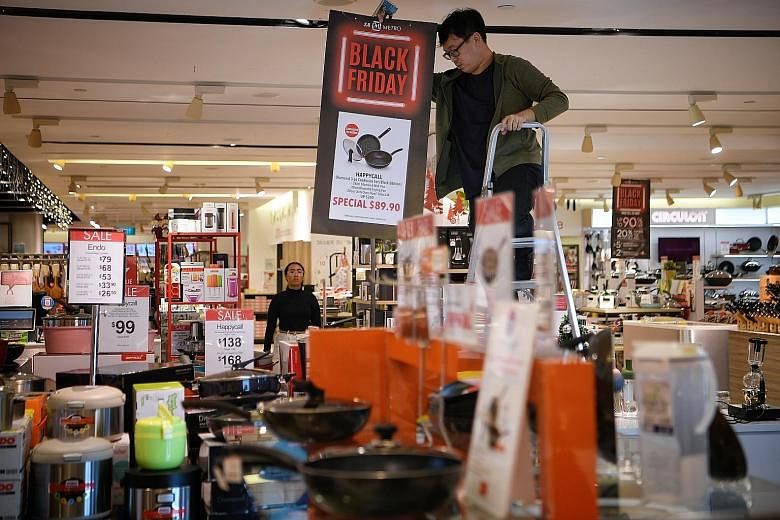 Promotional signs being put up as Metro geared up for the Black Friday sale at its Centrepoint store yesterday. The retailer is opening at 7.30am today, and offering discounts of up to 90 per cent. The queue outside Robinsons at The Heeren at around 