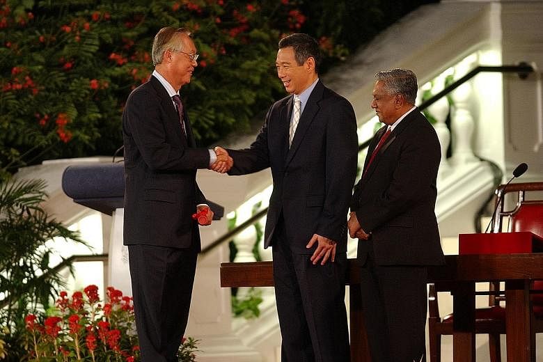 Above: Mr Goh Chok Tong with Mr Lee Hsien Loong at Mr Lee's swearing-in ceremony as prime minister at the Istana on Aug 12, 2004. Right: Mr Heng Swee Keat (far right) and Mr Chan Chun Sing with students in 2012. Mr Heng is set to be named the People'