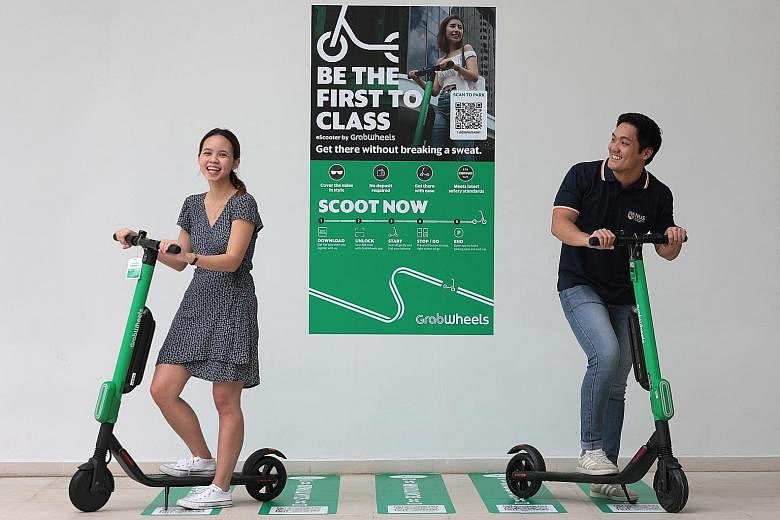 NUS students Melodie Claire Wong and Nicholas Tey with the GrabWheels e-scooters. There are eight GrabWheels parking stations at the school's Kent Ridge campus, and Grab aims to increase the number of such stations to 30 by the year end.