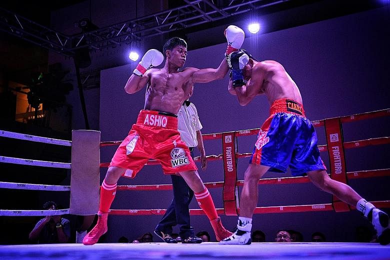 Singapore's Muhammad Ashiq (left) landing a left on Indonesian Galih Susanto during their World Boxing Council International Silver super bantamweight title bout yesterday.