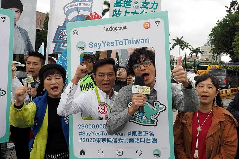 Taiwanese with referendum posters reading "Say Yes To Taiwan" and "Call Us Taiwan at Tokyo Olympics", urging people to vote in favour of the name change in today's polls.