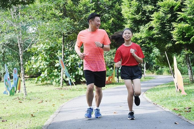 Tan Hui Keong, 42, running with his daughter Michelle, 10, one the youngest participants in this year's Standard Chartered Singapore Marathon. The family goes jogging together two to three times a week.