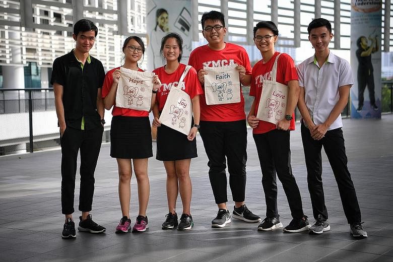 The EduTomahawk team (in red T-shirts) comprising ITE students (from second from left) Gan Shi Ying, 18; Cheryl Ee, 18; Tan Jia Shun, 19; and Josh Ang, 19, with samples of the tote bags they sold to raise funds for underprivileged children from Canos