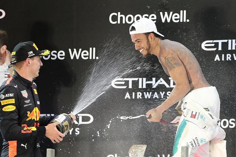 Mercedes' Lewis Hamilton celebrating his Abu Dhabi victory yesterday with third-placed Max Verstappen of Red Bull. With 51 wins from his last 100 races, the Briton has maintained his average of 10 a season since the turbo-hybrid era began in 2014.