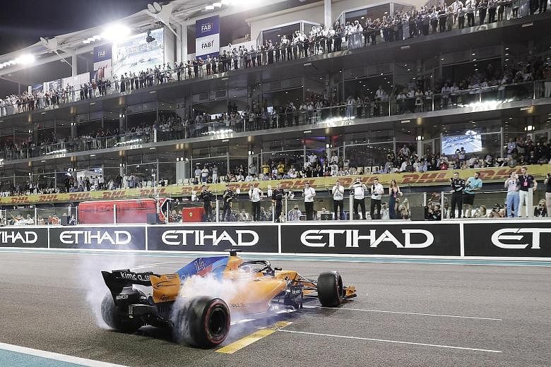 Fernando Alonso of McLaren performing a doughnut spin for thrilled fans after the Abu Dhabi Grand Prix at the Yas Marina Circuit on Sunday.