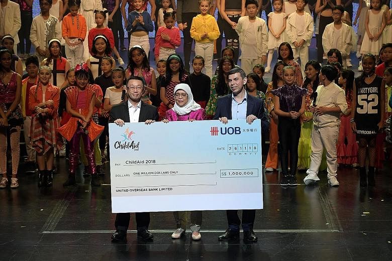 Far left: President Halimah Yacob witnessing the cheque presentation for UOB's donation of $1 million last night with UOB's Mr Choo Kee Siong (left), who is managing director and head of enterprise banking and commercial banking, and Mr Warren Fernan