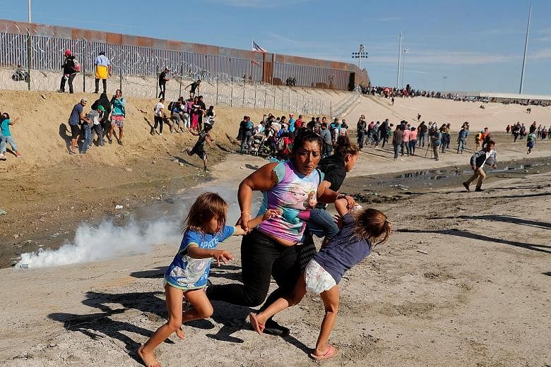 Ms Maria Lila Meza Castro, a 39-year-old migrant woman from Honduras, part of a caravan of thousands from Central America trying to reach the United States, running away from tear gas with her five-year-old twin daughters, Saira Nalleli Mejia Meza (l