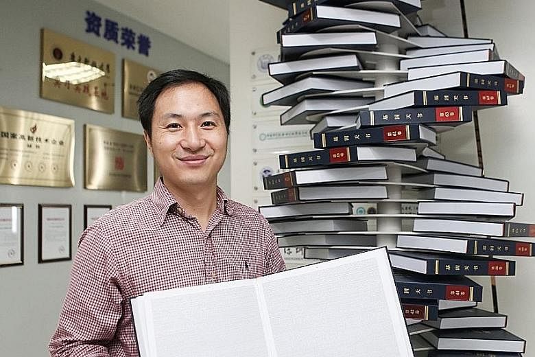 Chinese scientist He Jiankui at his company, Direct Genomics, in Shenzhen in China's Guangdong province in 2016. He is holding The Human Genome, a book that he edited. He has defended what he said he had achieved - embryonic gene editing to help prot