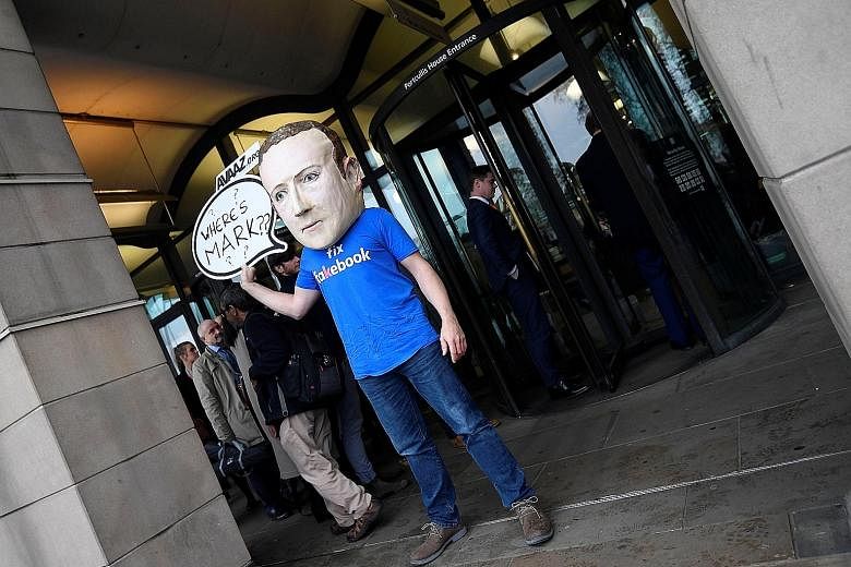 A campaigner wearing a Mark Zuckerberg mask after the Facebook chief failed to attend a hearing in London on Tuesday.