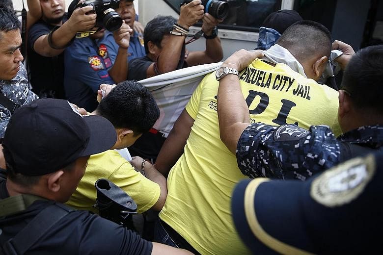 Two of the police officers (below, in yellow) convicted of the murder of teen Kian delos Santos (left) being taken out of a Caloocan city court building yesterday.