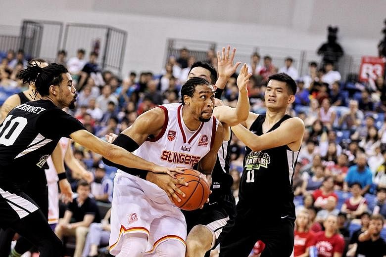 Singapore Slingers' John Fields trying to fend off the challenges of three Macau Black Bears players in their Asean Basketball League game at the OCBC Arena last night. The American centre starred in the Slingers' 98-88 victory with a game-high 32 po
